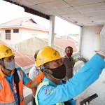 Petugas PLN melakukan penambahan daya kepada salah satu pelanggan.