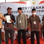 Menteri ATR/BPN Hadi Tjahjanto kiri saat menyerahkan sertifikat tanah kepada warga Desa Tambakasari.