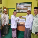 Ketua PD DMI Bangkalan, KH Mondir Rofii, saat menyerahkan bantuan untuk Pelestina kepada Ketua Baznas Bangkalan, KH Jazilul Nur.