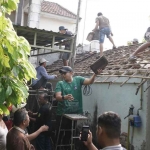 Pj Wali Kota Mojokerto saat membaur bersama warga dalam perbaikan salah satu rumah lansia.