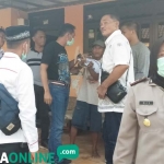 Pelaku (tengah bertopi) saat menjalani rekonstruksi dikawal petugas Polres Tuban. foto: GUNAWAN/ BANGSAONLINE