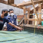 Erwin Wahyu Nugroho dan Kepala Disperdagin Jatim, Drajat Irawan, saat melihat proses pembuatan tenun ikat di Kampung Tenun Ikat, Bandar Kidul, Kota Kediri. Foto: Ist