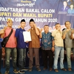 Ahmad Nadir menyerahkan formulir bacabup ke Sekretaris Bapilu Nasdem Hasanudin Farid. foto: SYUHUD/ BANGSAONLINE