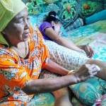 Korban Eka menahan sakit saat diobati ibunya di kediamannya, Desa Prekbun, Pademawu Pamekasan. foto: erry sugianto/ BANGSAONLINE
