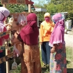 Warga desa Plalangan, Ponorogo saat menggantungkan bahan sembako di tempat Wage untuk diambil oleh warga yang terdampak Covid-19.