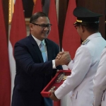 Aries Agung Paewai saat menerima cendera mata dari Wali Kota Batu, Nurochman.