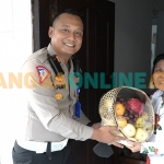 Kasatlantas Polres Gresik, AKP Agung Fitransyah, saat menyerahkan bingkisan kepada istri almarhum Aiptu Jailani. Foto: SYUHUD/BANGSAONLINE