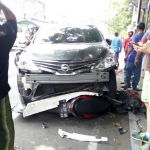 Salah satu motor korban masih tersangkut di kolong mobil.