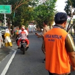 Mudika (muda mudi Katolik) terlihat ikut mengatur arus lalu lintas di depan Masjid Raya Miftahul Jannah Wlingi.