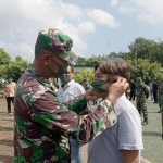 Kasdim Tuban saat memakaian masker kepada warga sekitar Kodim.