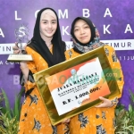 Novita Hardiny (kiri) memerkan trofi juara Lomba Masak Ikan Tingkat Provinsi Jatim. foto: HERMAN/ BANGSAONLINE