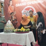 Pemilik Indah Bordir, Laila Cahyawati (kerudung orange) memotong tumpeng pada opening Indah Bordir di jalan MERR Rungkut Surabaya.
