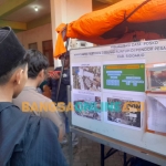 Keluarga korban melihat informasi di Posko Basarnas di area Ponpes Al Khoziny, Kamis (2/10/2025). foto: Mustain/BANGSAONLINE