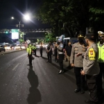 Petugas Polres Gresik saat melakukan penyekatan untuk mencegah penularan PMK hewan ternak sapi. Foto: SYUHUD/BANGSAINLINE.