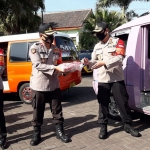 Kapolres Batu AKBP Harviadhi Agung Prathama (kanan) ikut angkat-angkat beras yang akan disalurkan.