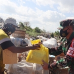 Dandim 0817 Gresik Letkol Inf Taufik Ismail bersama Kapolres Gresik AKBP Arief Fitrianto ketika membagikan bantuan kepada warga terdampak Covid. foto: SYUHUD/BANGSAONLINE