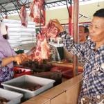 Kepala UPT Pasar Kedung Maling Fatkur Rohman saat berbincang dengan salah satu pedagang.