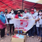 Relawan Bara JP saat menyerahkan ribuan masker di Posko Darurat Covid Gresik. foto: SYUHUD/ BANGSAONLINE