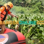 Plh Gubernur Jawa Timur, Adhy Karyono, saat turun dalam pembersihan eceng gondok. Foto: DEVI FITRI AFRIYANTI/BANGSAONLINE