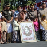 Wali Kota Risma, Wawali Whisnu, dan jajaran Forkopimda foto bersama berikut sebuah lukisan wajahnya yang dihiasi pula dengan bunga-bunga Tabebuya. foto: ist