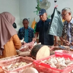 Kasatreskrim Polres Tuban AKP Rianto bersama diskompumdag saat mengecek harga daging di Pasar Baru Tuban.