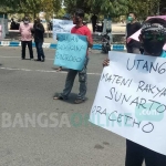 Aksi sejumlah mahasiswa dan warga di Gedung DPRD Ponorogo digelar dengan menerapkan protokol kesehatan. Mereka menuntut pembatalan utang oleh Pemkab Ponorogo kepada PT. SMI.