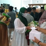 Para ibu-ibu saat menerima bingkisan berupa beras 5 kg, sarung dan uang Rp 100.000 di Masjid Kampus IKHAC Pacet Mojokerto Jawa Timur, Selasa (5/4/2022) malam. foto: MMA/ BANGSAONLINE