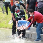 SIMBOLIS: Bupati Muhdlor melepas ribuan ikan di kolam pancing Perum SKI Sidoarjo, Minggu (6/3). foto ist.