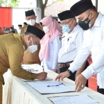 Bupati Gus Yani menandatangani berita acara mutasi. Sementara perwakilan pejabat yang dilantik tanda tangan pakta integritas. foto: SYUHUD/ BANGSAONLINE