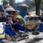 PEDULI: Siswa SMP Muhammadiyah 5 Tulangan, saat aksi mengajak warga membeli ikan hasil tangkapan nelayan, depan Kantor DKP Sidoarjo, Rabu (6/4). foto: musta’in/ BANGSAONLINE