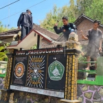 Warga perguruan silat yang secara sukarela menertibkan tugu. Foto: Ist