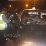Petugas memeriksa satu per satu mobil beserta penumpangnya. foto: ZAINAL ABIDIN/ BANGSAONLINE