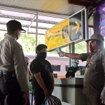 Petugas saat mengukur suhu tubuh calon penumpang KA di Stasiun Kereta Api Kediri. 
