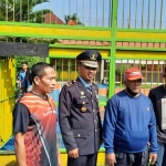 Suwarno memakai kaos lengan panjang warna biru dan bertopi merah, saat foto bersama Kalapas Tuban.