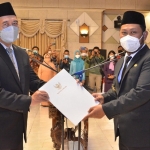 Sekda Gresik, Achmad Washil MR bersama Bupati Gus Yani menunjukkan SK pelantikan. foto: SYUHUD/ BANGSAONLINE