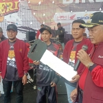 Bupati Malang Sanusi (kanan) saat menyerahkan doorprize berupa satu unit motor.