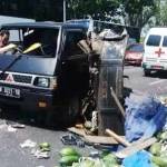 Truk pikap dan ambulan yang mengalami kecelakaan sebelum dievakuasi. Pepaya muatan pikap berserakan di jalan. 