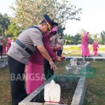 Kapolres Bangkalan AKBP Boby Paluddin Tambunan didampingi Ketua Cabang Bhayangkari Bangkalan saat tabur bunga di TMP. foto: FAUZI/ BANGSAONLINE
