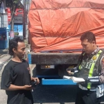 Petugas dari Satlantas Polres Gresik ketika menindak sopir truk angkutan barang yang melanggar aturan pada Operasi Patuh Semeru 2025. Foto: Ist