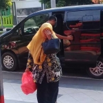 Tersangka Siti Ngatinah menutup wajahnya saat tiba di kantor Kejari untuk memenuhi panggilan penyidik.