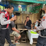 Petugas memeriksa botol berisi miras saat penggerebekan warung rica-rica mentok di Kota Mojokerto.