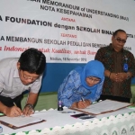 Ketua Semen Indonesia Foundation, Soesetyoko Suwandi (kiri) menandatangani nota kesepahaman kerjasama membangun sekolah peduli dan berbudaya lingkungan dengan 27 kepala sekolah di Madiun disaksikan oleh Kepala Dinas Pendidikan, Kebudayaan, Pemuda, dan Olahraga Kota Madiun, Gandhi Hatmoko (kedua kanan) di SMPN 5 Madiun.