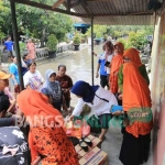 Tim Bantuan PKK Kota Mojokerto turun langsung ke lokasi banjir untuk menyerahkan  bantuan bahan pokok.