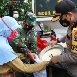 Kapolres Mojokerto sedang memberikan bantuan beras kepada salah satu warga.