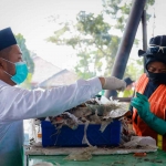 Bupati Gresik, Fandi Akhmad Yani saat mencoba mesin RDF untuk pembuatan briket. Foto: SYUHUD/BANGSAONLINE.com