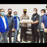 Ketua DPD Nasdem Gresik Syaiful Anwar didampingi pengurus dan anggota Fraksi Nasdem DPRD Gresik menyerahkan tumpeng kepada Wakapolres Gresik Kompol Eko Iskandar. foto: SYUHUD/BANGSAONLINE