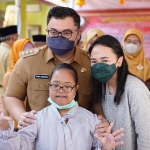 Bupati Kediri Hanindhito Himawan Pramana dan Ketua Yayasan Dharma Wanita Eriani Annisa Hanindhito, bersama salah satu siswi penyandang disabilitas. Foto: Ist.