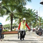 Para pekerja saat akan menata bangku di sekitar monumen SLG. Foto: Ist