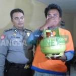 SAYANG ANAK: Tersangka Moch Dulhijah menunjukkan tabung elpiji melon yang dicuri untuk pengobatan anaknya yang sakit ketika di Mapolsek Taman. foto: catur andy/ BANGSAONLINE