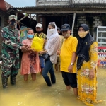 Dyah Roro Esti (kerudung putih) saat menyerahkan bantuan kepada korban banjir luapan Kali Lamong. foto: SYUHUD/ BANGSAONLINE